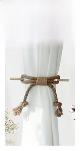 Close-up of hand-woven cotton rope curtain tieback with a wooden stick fastener
