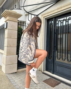Detail of vintage paisley quilted jacket with blue contrast piping and casual loose fit