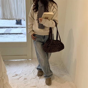 Borsa tote con stampa leopardata abbinata a outfit invernale e sciarpa a righe in studio