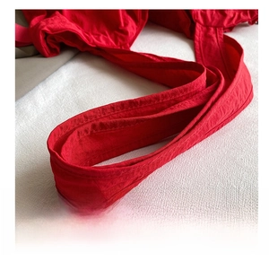 Detailed close-up of vibrant red wide fabric strap with durable double stitching