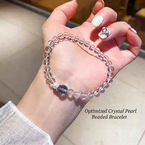 Bracelet chic en perles de cristal blanc et perle naturelle présenté sur une main