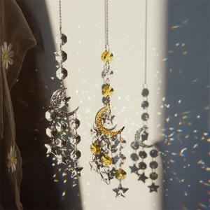 Detail of suncatchers with moon and star pendants creating rainbow light on the wall