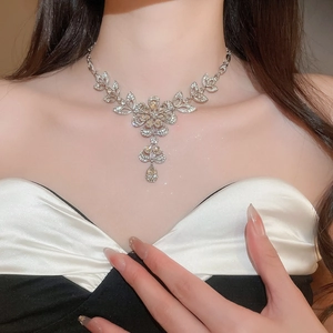 Close-up of elegant silver flower necklace with sparkling crystals and leaf design