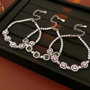 Détails de bracelets en zircon blanc, vert et rose sur un plateau de présentation noir