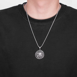 Detail of silver Viking wolf head pendant with runic circle on a long box chain for men