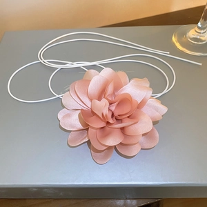 Macro shot of handcrafted pink silk flower choker with soft layered petals and thin cord