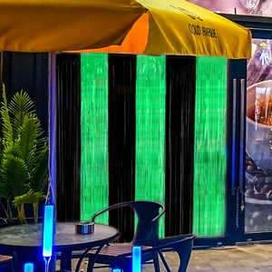 Detail of green and black fringe curtain backdrop at a cafe entrance for festive decor