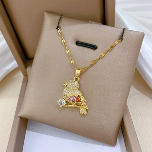 Macro shot of gold bird pendant necklace with sparkling colorful zircon in a jewelry box