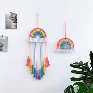Detail of handmade woven rainbow wall hanging with colorful tassels for home decor
