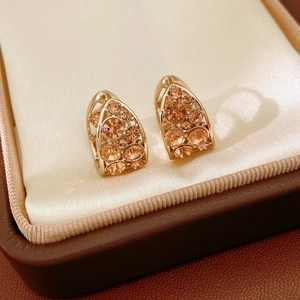 Gros plan détaillé de boucles d'oreilles gouttes couleur champagne serties de cristaux de luxe