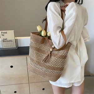 Retro woven straw tote bag with leather straps and fringe detail for beach holidays