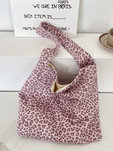 Leopard print canvas tote bag with wide shoulder strap displayed on white steps