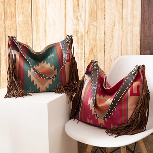 Detail of bohemian woven tote bag with fringe accents and tribal sun pattern