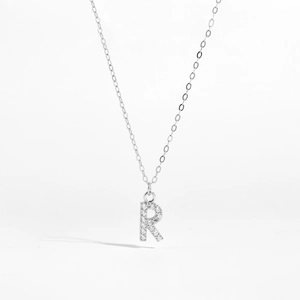 Close-up of S925 silver letter R pendant featuring micro-paved sparkling cubic zirconia