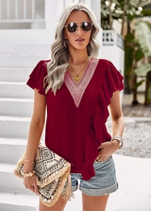 Close-up of V-neckline with white lace embroidery on burgundy ruffle sleeve top