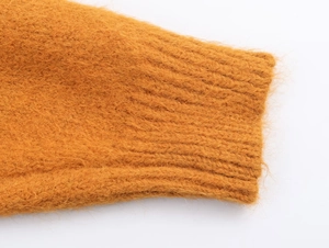 Détail du pull en maille mohair jaune moutarde montrant les poignets côtelés doux