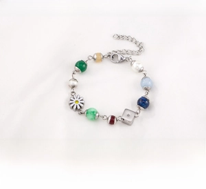 Detail of titanium steel bracelet featuring colorful beads, daisy and dice charms