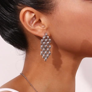 Detailed close-up of bohemian silver chain strap earrings with woven metal structure