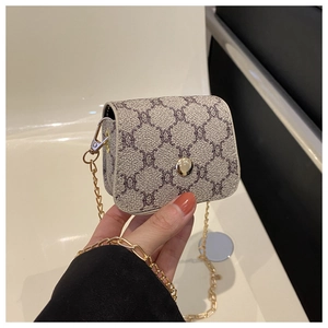 Detail of a mini chain bag with geometric pattern and golden metal buckle being held