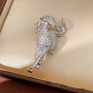 Macro view of a silver horse brooch with sparkling zircons on a golden satin jewelry box