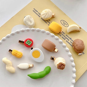 Macro detail of various resin food-shaped hair clips like fried eggs and buns