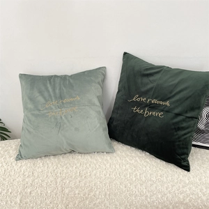 Close-up of elegant gold embroidery and velvet fabric texture on decorative cushions