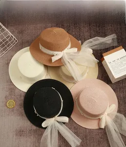 Detailed flat lay of colorful straw hats with pearl net ribbons for summer vacation