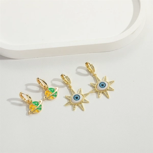 Vintage gold earrings featuring colorful enamel planet and evil eye star motifs with crystals