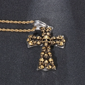 Macro shot of gothic cross pendant featuring detailed skull relief on golden rope chain