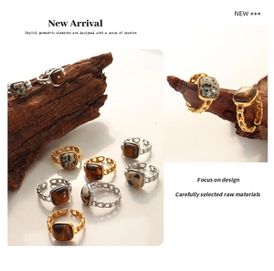 Macro detail of retro chain ring featuring inlaid tiger eye and spotted natural stones