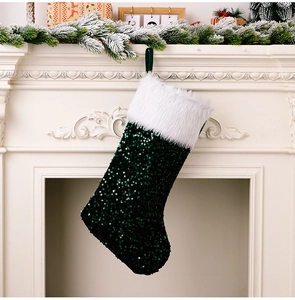Détail d'une chaussette de Noël en paillettes vert foncé avec revers en fourrure