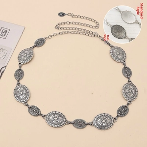 Detail of bohemian silver metal concho belt with sunburst texture and lobster clasp