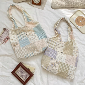Detailansicht der floralen Patchwork-Taschen mit Steppmuster und gewebtem Markenetikett