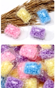 Detailed view of colorful laundry scent booster beads in individual clear packaging