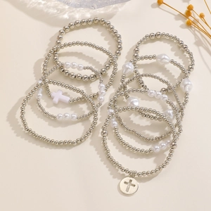 Dettaglio del set di braccialetti elastici con perline, ciondoli a croce e perle argentate