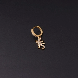 Detailed view of a gold lizard pendant earring with micro-pave cubic zirconia on black background