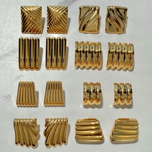 Macro shot of 18K gold plated stainless steel earrings with geometric wave textures