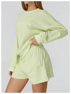 Detail view of light green sweatshirt and shorts set with white stripe trimmings