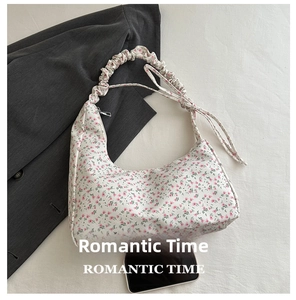 Sac hobo à fleurs avec bandoulière plissée présenté à côté d'un smartphone pour la taille