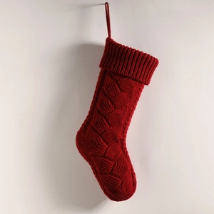 Detailed close-up of dark red cable knit texture on a large hanging Christmas stocking