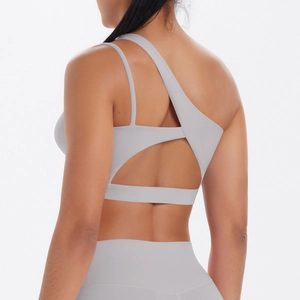 Detail of light grey sports bra showing asymmetric straps and open back design