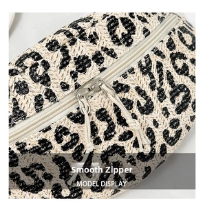 Close-up of leopard print straw waist bag with smooth metal double zippers and tassels