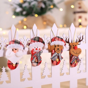 Set of 4 Christmas ornaments featuring Santa, Snowman, Bear and Reindeer hanging on fence