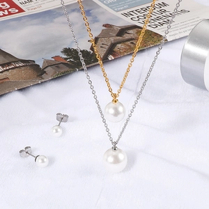 Elegant double-layer pearl necklace and stud earrings set on white textured fabric