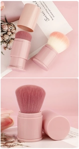 Detail of pink retractable makeup brush with gradient bristles and protective lid
