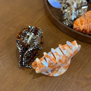 Detailed texture of acetate hair claws in tortoise shell and marble candy colors on wood