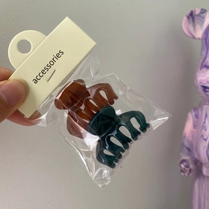 Detail view of mini jelly hair claws in brown and dark cyan with accessories card