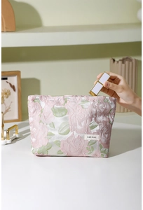 Gros plan sur la texture jacquard florale et l'étiquette de la trousse de toilette