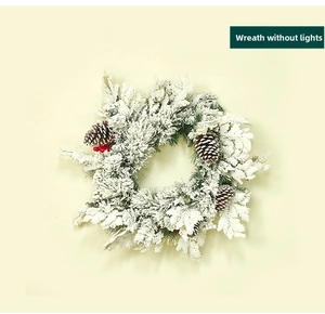 Close-up of Christmas wreath with artificial snow, pine cones, and red berries without lights