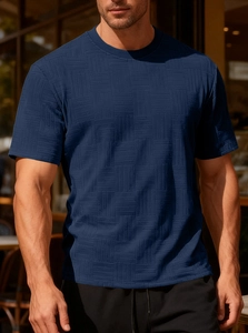 Detail of dark blue crew neck t-shirt featuring a textured waffle knit mesh fabric